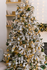 Christmas decor, beautiful snow-covered Christmas tree with toys and lights