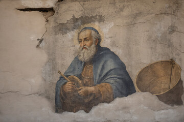 Alte Wand als Leinwand mit dem Apostel Petrus gemalt, altes Gemälde, Rissig, Ausgewaschen, der Putz bröckelt ab, das Porträt ist wie die Wand gerissen.