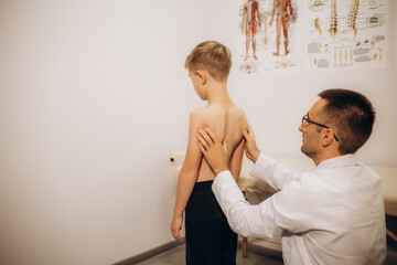 orthopedist examines the back of a young child