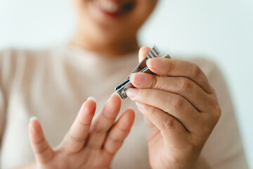A woman is holding a pair of nail clippers