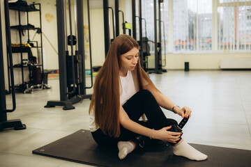 a woman in a rehabilitation center puts straps on her legs