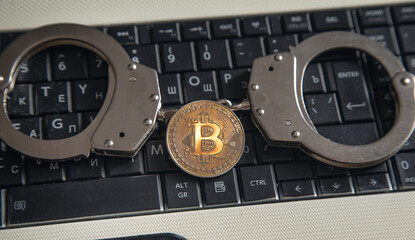 Golden bitcoin and handcuffs. Virtual currency