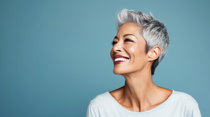 Elegant, smiling elderly, chic latino, Spain woman with gray hair and perfect skin, blue background banner. - obrazy, fototapety, plakaty
