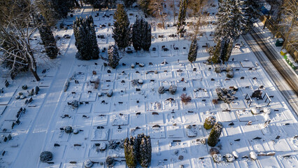 Drone photography of a large cemetery in a forest covered by snow during winter day