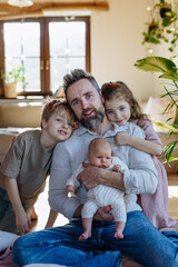 Portrait of father holding newborn baby, enjoying all his kids. New sibling. Unconditional paternal love, Father's Day concept. - obrazy, fototapety, plakaty