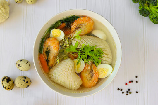 Seafood soup with squid, shrimp and boiled egg. Diet food.