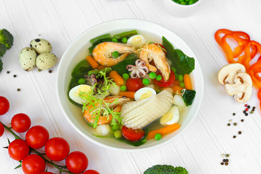 Seafood soup with squid, shrimp and boiled egg. Diet food.