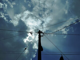 Silhouette of electric pole under the sky
