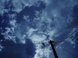 Silhouette of electric pole under the sky