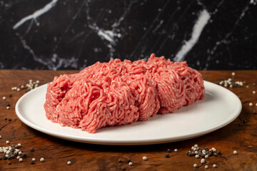 Ground beef. Butcher products. Fresh minced meat on dark background. Close up