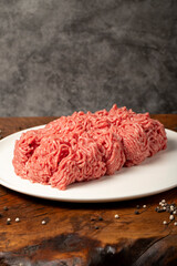 Ground beef. Butcher products. Fresh minced meat on dark background. Close up