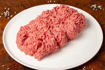 Ground beef. Butcher products. Fresh minced meat on dark background. Close up