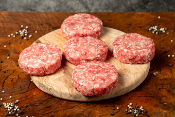 Raw hamburger patty. Butcher products. Fresh hamburger patty meat on dark background