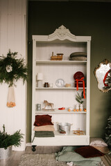 Stylish interior with a white sideboard and a Christmas tree decorated for the new year