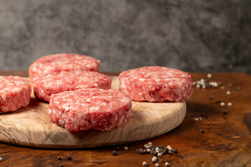 Raw hamburger patty. Butcher products. Fresh hamburger patty meat on dark background. Close up