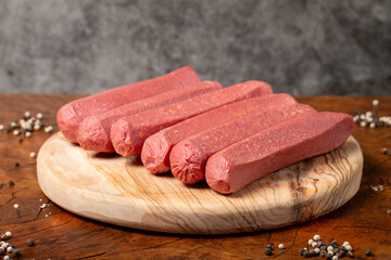 Raw sausage. Butcher products. Sausages made from uncooked beef on a dark background