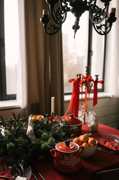 Beautiful New Year decor, a Christmas table with a red tablecloth and candles, festive dishes and glasses