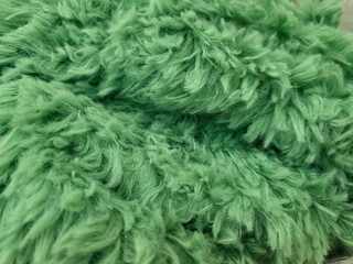A green fluffy new carpet under your feet, in the hallway or bathroom.