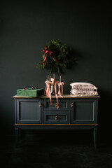 Beautiful New Year decor, a Christmas wreath on a vintage chest of drawers in a stylish dark living room interior