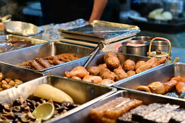 At a stall in Nanjichang Night Market, this close-up shows meatballs with various ingredient options like chicken wings and pig's blood cake available.