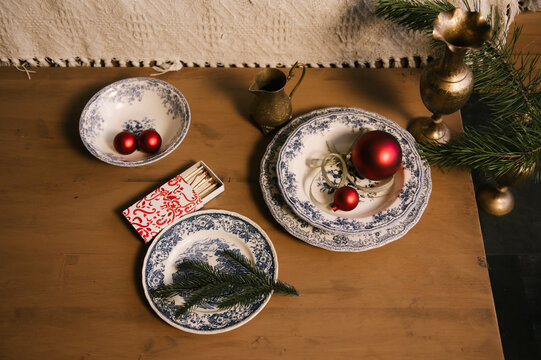Beautiful New Year decor, red balls in vintage plates and gold candlesticks