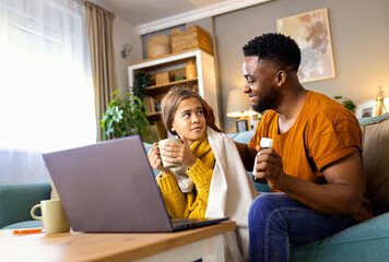 African American father and daughter with fever sitting at home and have online consultations with...