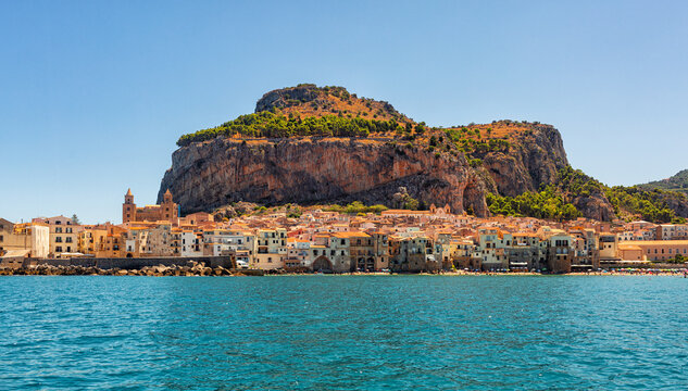 Panoramic view of Cefal&ugrave;, Metropolitan City of Palermo, coastal town in Sicily, Italy.  Old buidings, the Duomo, a Norman Cathedral and La Rocca, a rocky mountain, summer time, august 2023.