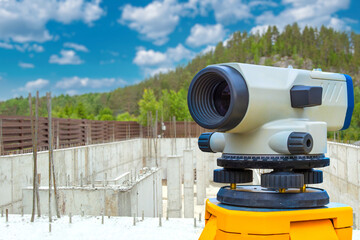 Precision Surveying Equipment Overlooking a Construction Site with Reinforced Concrete Foundations