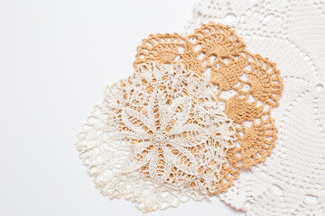 three crocheted and knitted napkins lie on a white background close-up. Handicrafts as a way of...