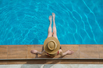 Woman in a big hat chilling in swimming pool, top view - 761319848