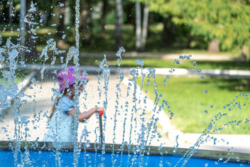 Water jets in the fountain on a summer day in the park.