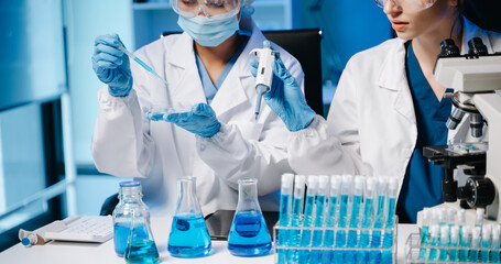 Modern Medical Research Laboratory Portrait of Two African American Scientists Working, Using Digital Tablet, Analyzing Samples, Talking. .