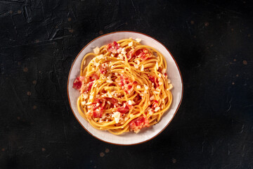 Carbonara pasta dish, traditional Italian spaghetti with pancetta and cheese, overhead flat lay shot on a black background - 761332488