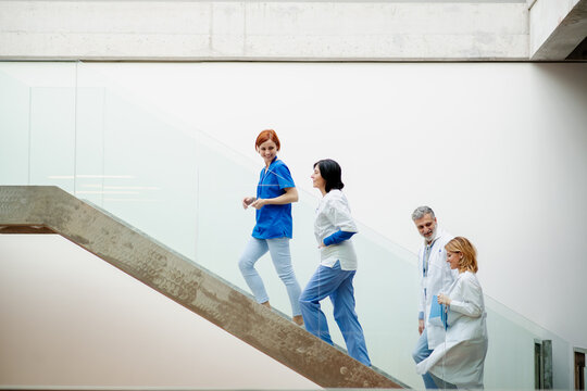 Portrait of team of doctors standing on stairs. Healthcare team with doctors, nurses, professionals in medical uniforms in hospital.