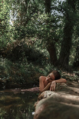 Woman peacefully embracing sleep in a dreamlike river. Concept of spiritual connection with the...