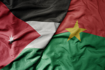 big waving national colorful flag of burkina faso and national flag of jordan.