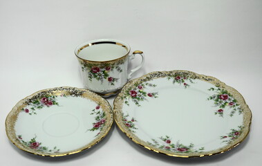 Three-piece dinner service, porcelain with elaborate gold ornamentation and floral decoration, cup and saucer with red cabbage rose decoration