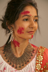 Portrait of beautiful young indian woman in traditional dress on holi festival.