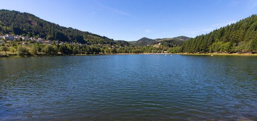 Fototapeta na wymiar Au coeur des monts d'Ardèche, à 850 mètres d'altitude, niche le lac artificiel de Saint-Martial. Ce vaste plan d'eau est très apprécié des baigneurs. Il s'étend au pied du mont Gerbier de Jonc.