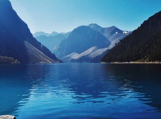 Deep blue lake and sky, surrounded by the silhouette of the mountains. Travel background.