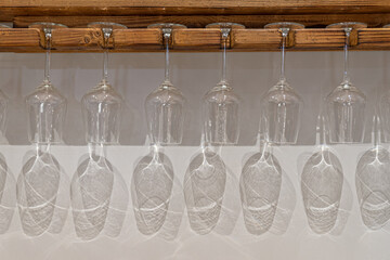 wine glasses with shadow reflection on wooden hanger and with space for copy