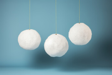 Three white snow globes hanging from blue background
