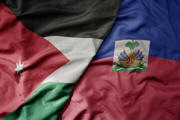 big waving national colorful flag of haiti and national flag of jordan.