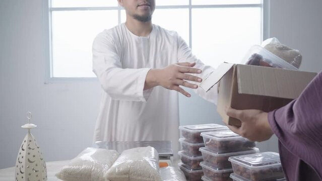 Muslim Man Giving Food Donation and Other Receive It. Zakat for Islamic Charity on Ramadan Month. 