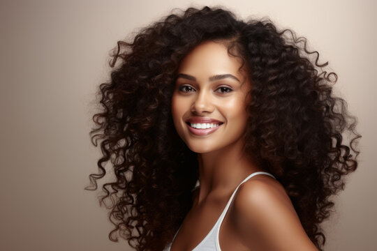 Woman with curly hair is smiling and posing for picture