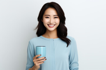 Woman is smiling and holding blue cup