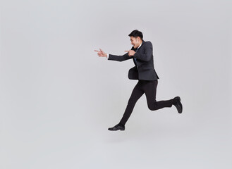 Fototapeta na wymiar full length of happy smiling young handsome Asian businessman jumping and pointing away isolated on white studio background.