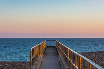 Looking out from a jetty over the ocean at sunset, at Seaford in Sussex