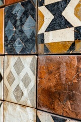 Vertical Mixed pattern tiled wall close up.