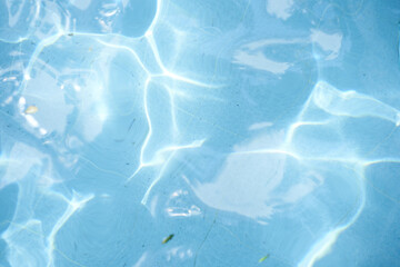 Top view of surface blue swimming pool, reflection on blue water, swirl pattern texture. Leaves in dirty water, opened swimming pool. Background, backdrop with copy space.